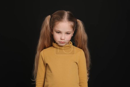 Little girl on black background. Children's bullying