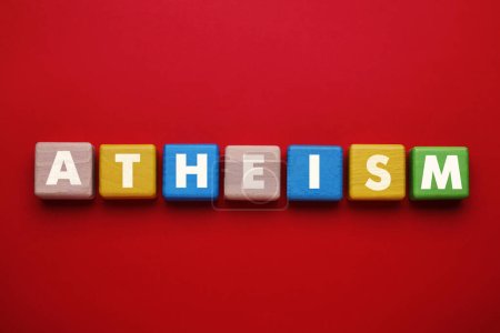 Photo for Word Atheism made of wooden cubes with letters on red table, top view - Royalty Free Image