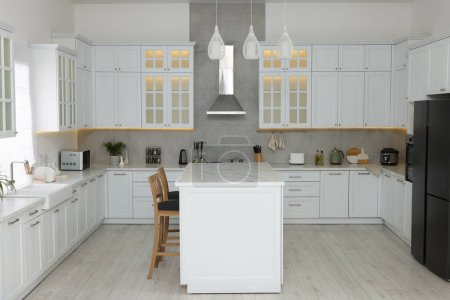 Foto de Elegante cocina con muebles modernos y diferentes electrodomésticos. Diseño de interiores - Imagen libre de derechos