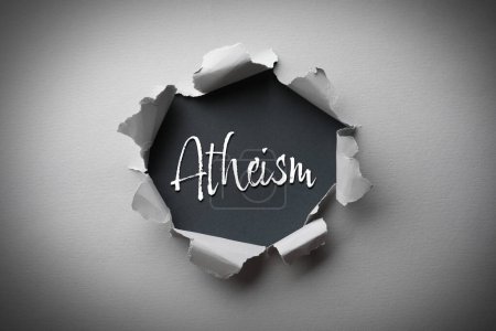 Téléchargez les photos : Mot Athéisme sur fond noir, vue à travers trou dans papier gris - en image libre de droit
