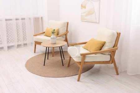 Stilvolle Sessel und Holztisch im Wohnzimmer. Innenarchitektur