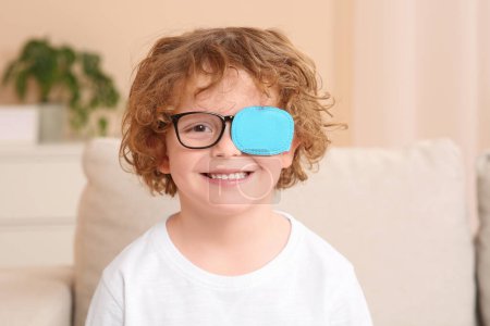 Photo for Happy boy with eye patch on glasses indoors. Strabismus treatment - Royalty Free Image