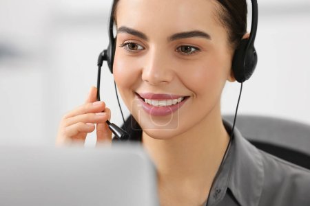Photo for Hotline operator with headset working on computer in office - Royalty Free Image