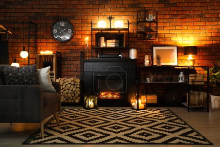 Téléchargez les photos : Élégant salon avec belle cheminée, fauteuil et décor différent la nuit. Design d'intérieur - en image libre de droit