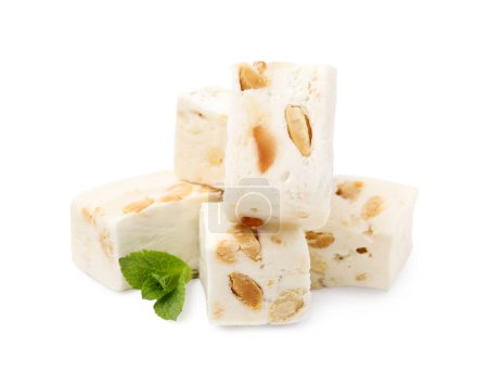 Pieces of delicious nougat and mint on white background