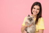 Happy woman hugging her cute cat on pink background, space for text Poster #655202836