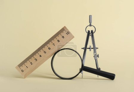 Photo for Ruler, magnifying glass and compass on yellow background - Royalty Free Image