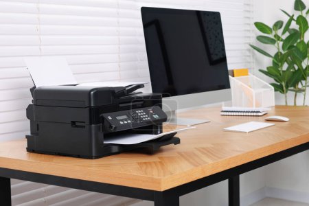 Photo for Modern printer with paper on wooden desk indoors - Royalty Free Image
