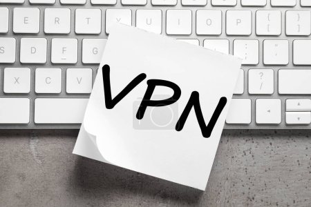 Téléchargez les photos : Feuille de papier avec acronyme VPN (Virtual Private Network) et clavier sur table grise, vue du dessus - en image libre de droit