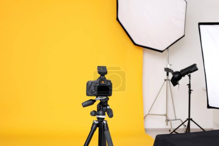 Téléchargez les photos : Caméra sur trépied et équipement d'éclairage professionnel dans un studio photo moderne - en image libre de droit