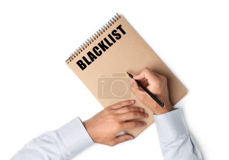 Téléchargez les photos : Homme écrivant le mot Blacklist dans le carnet sur fond blanc, vue du dessus - en image libre de droit