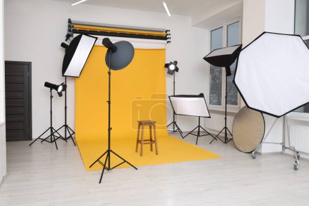 Foto de Interior del moderno estudio fotográfico con taburete de bar y equipo de iluminación profesional - Imagen libre de derechos