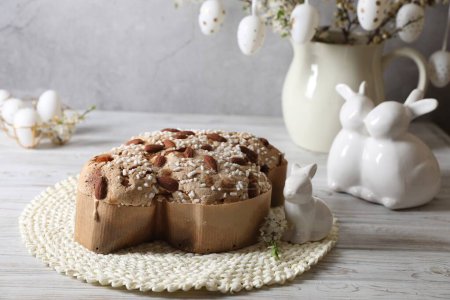 Foto de Delicioso pastel de paloma de Pascua italiana (Colomba di Pasqua) y decoración festiva en mesa de madera blanca - Imagen libre de derechos