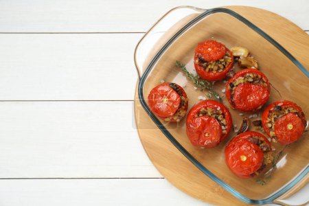 Foto de Deliciosos tomates rellenos con carne picada, bulgur y champiñones sobre mesa de madera blanca, vista superior. Espacio para texto - Imagen libre de derechos
