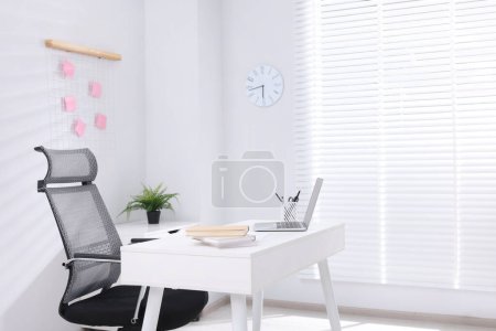 Schreibtisch und bequemer Stuhl im modernen Büro, Platz für Text. Innenarchitektur