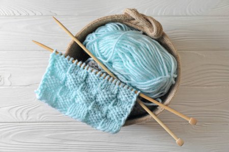 Photo for Soft turquoise yarn, knitting and needles on white wooden table, top view - Royalty Free Image