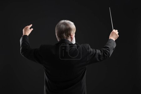 Foto de Conductor profesional con bastón sobre fondo negro, vista trasera - Imagen libre de derechos