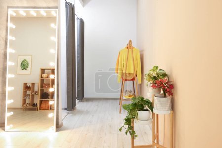Photo for Stylish dressing room interior with mirror and clothing rack - Royalty Free Image