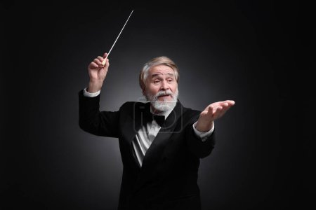 Photo for Professional conductor with baton on black background - Royalty Free Image