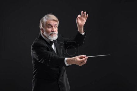Foto de Conductor profesional con bastón sobre fondo negro - Imagen libre de derechos