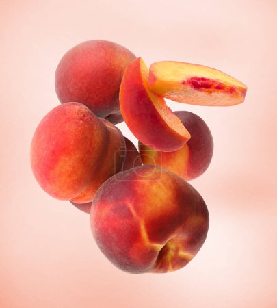 Photo for Cut and whole fresh ripe peaches falling on pink background - Royalty Free Image