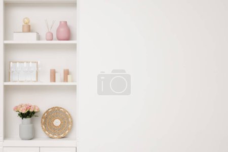 Photo for Shelves with different decor near white wall, space for text. Interior design - Royalty Free Image
