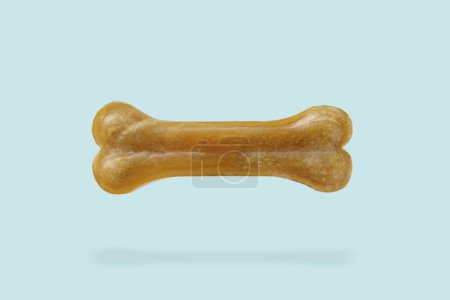Photo for Bone dog treat in air on light blue background - Royalty Free Image