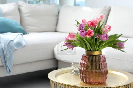 Foto de Hermoso ramo de flores de tulipán de colores en la mesa de café en la habitación, espacio para el texto - Imagen libre de derechos