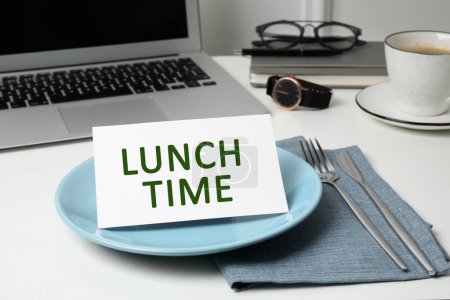 Almuerzo de negocios. Escritorio de oficina con placa, cubiertos y laptop. Tarjeta con frase Hora del almuerzo en el plato