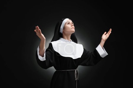 Foto de Monja rezando a Dios sobre fondo negro - Imagen libre de derechos