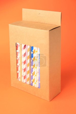 Photo for Box with many paper drinking straws on orange background - Royalty Free Image