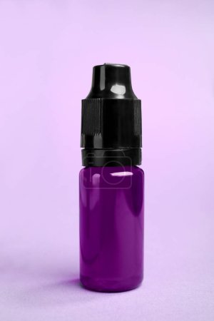 Téléchargez les photos : Bouteille avec colorant alimentaire violet sur fond lumineux - en image libre de droit