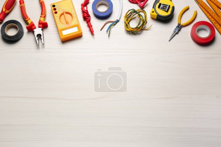 Téléchargez les photos : Différents fils et outils d'électricien sur table en bois blanc, pose plate. Espace pour le texte - en image libre de droit