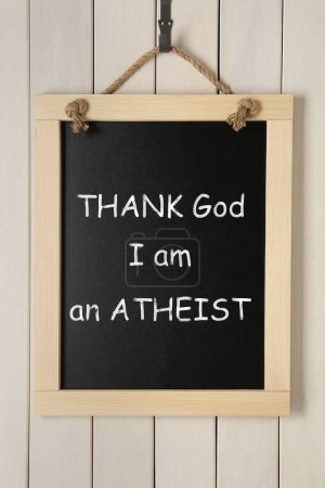 Téléchargez les photos : Petit tableau avec phrase Dieu merci je suis athée accroché près du mur en bois blanc - en image libre de droit