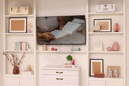 TV and shelves with different decor in room. Interior design