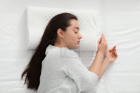 Téléchargez les photos : Femme dormant sur un oreiller en mousse à mémoire de forme, vue de dessus - en image libre de droit