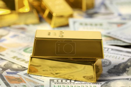 Photo for Shiny gold bars on dollar banknotes, closeup - Royalty Free Image