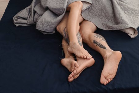 Photo for Passionate couple having sex on bed, closeup of legs - Royalty Free Image