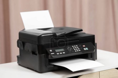 Téléchargez les photos : Imprimante moderne avec papier sur table blanche à l'intérieur - en image libre de droit