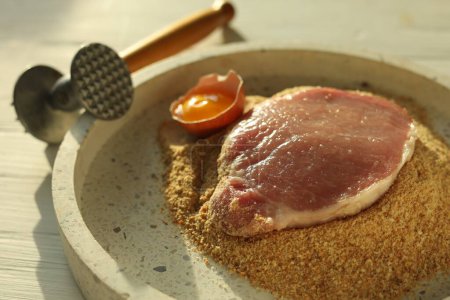 Téléchargez les photos : Schnitzel de cuisine. côtelette de porc cru, maillet de viande et ingrédients sur table en bois blanc, gros plan - en image libre de droit