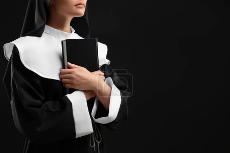 Foto de Monja con Biblia sobre fondo negro, primer plano. Espacio para texto - Imagen libre de derechos