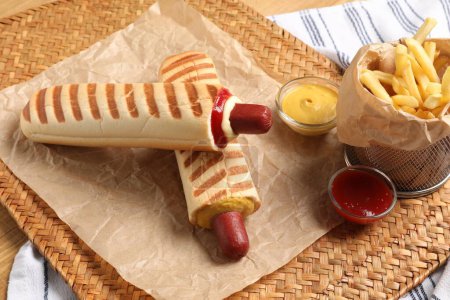 Téléchargez les photos : Délicieux hot-dogs français, frites et sauce trempette sur tapis en osier - en image libre de droit