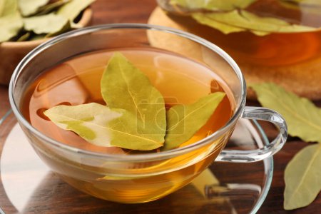 Téléchargez les photos : Tasse de thé fraîchement infusé avec des feuilles de laurier sur une table en bois, gros plan - en image libre de droit