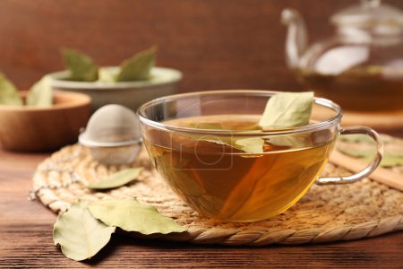 Téléchargez les photos : Tasse de thé fraîchement infusé avec des feuilles de laurier sur une table en bois, gros plan - en image libre de droit