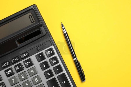 Photo for Calculator and pen on yellow background, flat lay. Space for text - Royalty Free Image