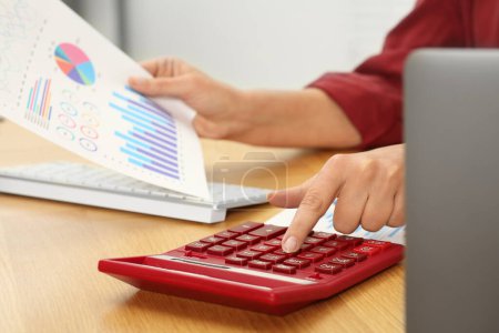 Photo for Accountant using calculator at wooden desk in office, closeup - Royalty Free Image