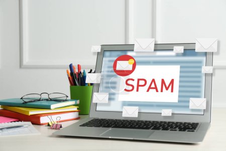 Téléchargez les photos : Message d'avertissement de Spam dans le logiciel d'email. Illustrations d'enveloppe surgissant de l'affichage d'ordinateur portable sur le bureau - en image libre de droit