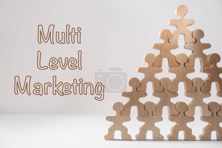 Téléchargez les photos : Marketing multi-niveaux. Pyramide de figures humaines en bois sur table blanche - en image libre de droit