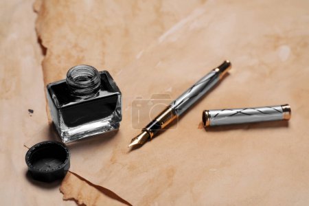 Photo for Inkwell and fountain pen on vintage parchment - Royalty Free Image
