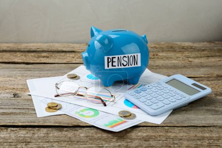 Sparschwein mit Wort Pension, Münzen, Gläsern, Taschenrechner und Diagrammen auf Holztisch. Rentenersparnis
